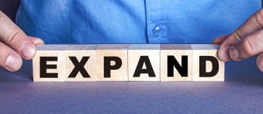 ExPAND kelimesi bir insan tarafından ahşap küplerden oluşur. İş konsepti