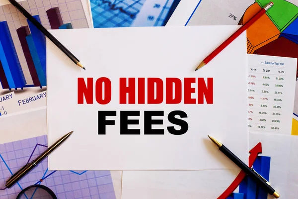 The words NO HIDDEN FEES is written on a white background near colored graphs, pens and pencils. Business concept