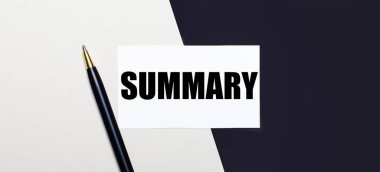 Siyah ve beyaz arkaplanda bir kalem ve beyaz bir kart bulunur..