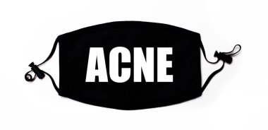 Açık arkaplanda siyah tıbbi yüz maskesi ve ACNE yazılı. Hastalık önleme. Tıbbi konsept