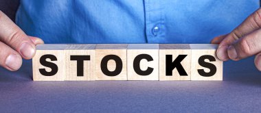 STOCKS kelimesi bir insan tarafından yapılmış tahta küplerden oluşur. İş konsepti