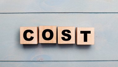 Açık mavi ahşap arka planda metni olan tahta küpler..