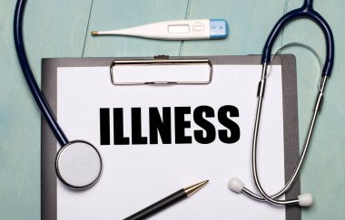 Açık mavi ahşap arka planda ILLNESS etiketli bir kağıt, steteskop, bir elektronik termometre ve bir kalem var. Tıbbi konsept
