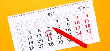 Sarı arka planda, kırmızı ile işaretlenmiş 14 numaralı 2021 takvimi var. Kırmızı sapın yanında.