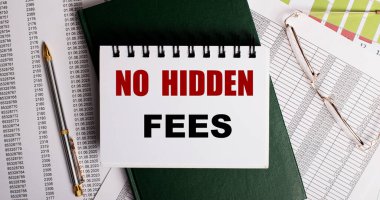 Masaüstünde raporlar, gözlükler, bir kalem, yeşil bir günlük ve üzerinde HAYIR ödemeleri yazan beyaz bir defter var. İş yeri, yakın çekim. İş konsepti