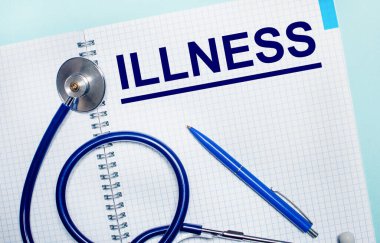 Açık mavi arka planda ILLNESS sözcüğünün olduğu açık bir defter, mavi bir kalem ve stetoskop. Yukarıdan bak. Tıbbi konsept