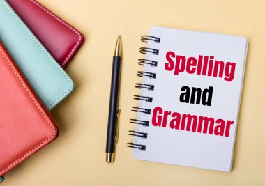 Çok renkli günlükler bej bir arka planda bir kalem ve defter üzerinde 