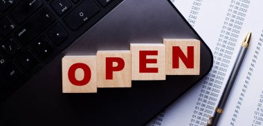 OPEN kelimesi kalemin yanındaki klavyede tahta küplere yazılır..