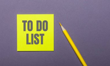 Gri arka planda, parlak sarı bir kalem ve üzerinde 