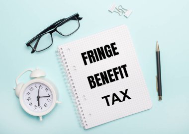 Açık mavi bir arka planda siyah gözlük ve bir kalem, beyaz bir çalar saat, beyaz ataçlar ve FRINGE BENEFIT Vergi yazılı bir defter bulunur. İş konsepti