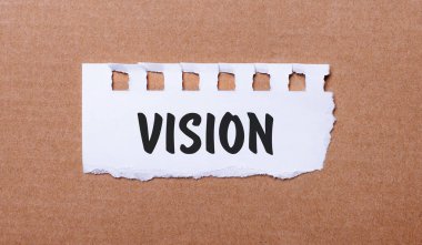 Kahverengi arka planda, üzerinde VISION yazan beyaz kağıt