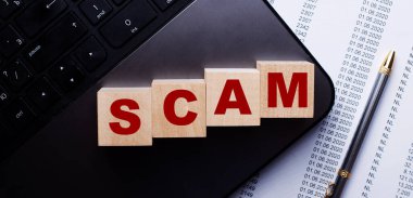 SCAM kelimesi kalemin yanındaki klavyede tahta küplere yazılır..