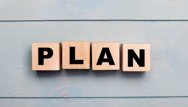 Açık mavi ahşap zemin üzerinde metin planı olan tahta küpler.