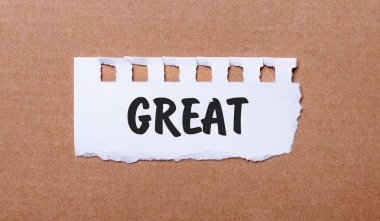 Kahverengi arkaplanda, beyaz kağıtta büyük yazılar var.