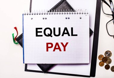 Hafif bir arka plan gözlüğü, bozuk paralar ve üzerinde EQUAL Pay yazan bir defter. İş konsepti