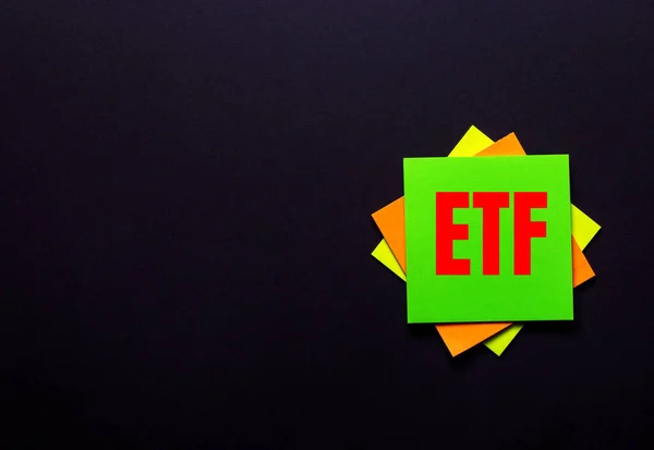 Koyu arkaplanda parlak bir çıkartma üzerinde ETF Ticaret Fonu kelimeleri. Boşluğu kopyala