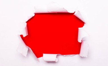 Kırmızı arka planda yırtık beyaz kağıt var. Şablon. Boşluğu kopyala