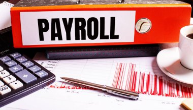 Kırmızı belge klasöründe kahve, hesap makinesi ve kalemin yanında PAYROLL yazıyor..