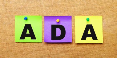 Bej bir arka planda, Engelli Amerikalılar Yasası yazan notlar için çok renkli çıkartmalar var.