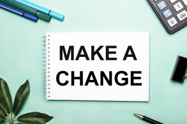 Değişiklik Yapın beyaz bir sayfa üzerine yazılır. Kırtasiyenin ve Scheffler kağıdının yanındaki mavi arka planda. Harekete geçin. Motivasyon kavramı