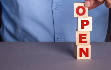 Mavi gömlekli bir adam dikey olarak tahta küplerden 