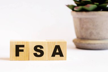 Hafif bir arka planda, üzerinde FSA Esnek Harcama Hesabı ve saksıda bir çiçek yazan tahta küpler. Odaklanmayın