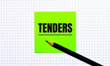 Üzerinde TENDERS yazan yeşil bir çıkartma ve kareli kağıtta siyah bir kalem var..