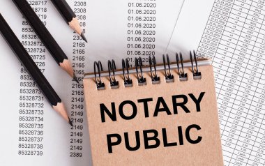NOTARY PUBLIC kelimeleri kahverengi deftere yazılmıştır. Yakın kalemler.