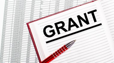 Raporların yanındaki masada içinde GRANT yazan bir günlük var. Yakınlarda kırmızı bir kol var..