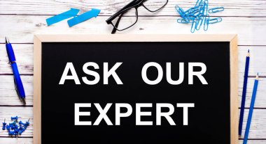 Uzmanımıza sor, mavi ataç, kalem ve kalemlerin yanında siyah bir not panosuna yazılmış..