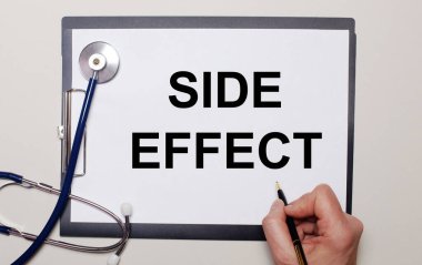 Hafif bir arkaplanda, steteskop ve bir sayfa kağıt, üzerine bir adam SIDE EFFECT yazıyor. Tıbbi konsept