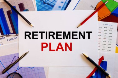 RETIREMENT PLAN kelimeleri renkli grafikler, kalemler ve kalemlerin yanında beyaz bir arkaplanda yazılmıştır. İş konsepti