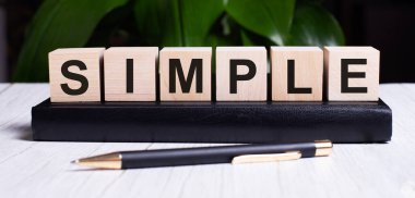 SIMPLE kelimesi günlüğün sapının yanındaki tahta küplerin üzerine yazılır..