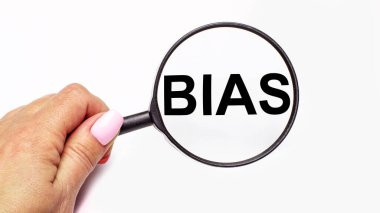 Kadın eli, üzerinde BIAS yazan bir büyüteç tutuyor.