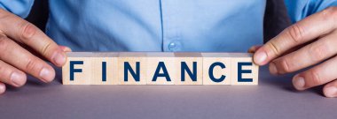FINANCE kelimesi bir insan tarafından tahtadan yapılmış küplerden oluşur. İş konsepti