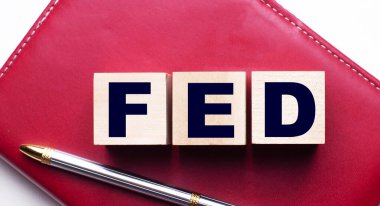 FED, ağılın yanındaki bordo bir defterin üzerinde duran tahta küplerden oluşuyor. İş konsepti