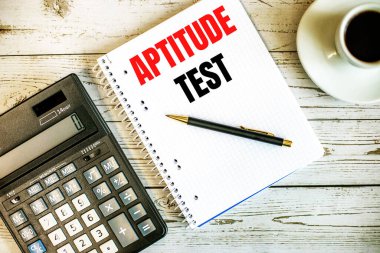 Kahvenin yanında beyaz kağıda ve açık ahşap bir masanın üzerinde hesap makinesi üzerine yazılmış bir test. İş konsepti