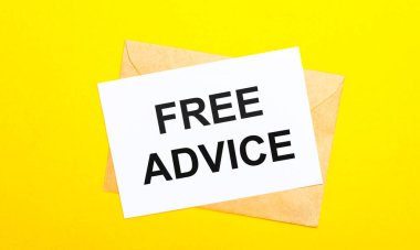 On a yellow background, an envelope and a card with the text FREE ADVICE. View from above