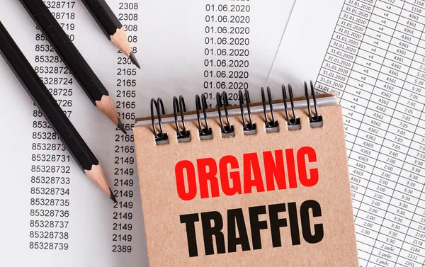 The words ORGANIC TRAFFIC is written on the brown notebook. Nearby pencils