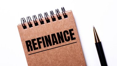 Hafif arkaplanda siyah bir kalem ve siyah yaylar üzerine kahverengi bir defter var.