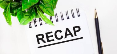 Beyaz arka planda yeşil bir bitki, üzerinde RECAP ve kalem yazan beyaz bir defter.