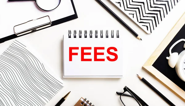 Bir ışık masasında defterler, bir büyüteç, bir çalar saat, bir gözlük ve bir kalem vardır. Ortasında da metin fiyatlarının yazılı olduğu bir defter var.
