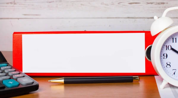 Red folder for papers with place to insert text, white alarm clock, calculator and pen on the desktop. Template. Business concept
