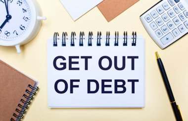 Hafif bir arkaplanda, beyaz bir çalar saat, bir hesap makinesi, bir kalem ve bir defter var. Düz yatıyordu