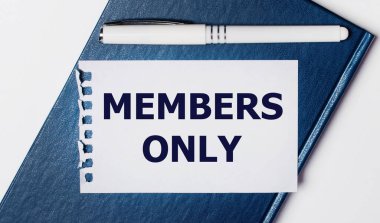 Mavi günlük arka planda yatıyor. Üzerinde sadece metin üyeleri olan beyaz bir kalem ve bir kağıt parçası var..