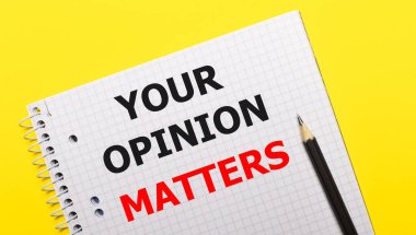 Üzerinde yazı olan beyaz defter. Parlak sarı arka planda siyah kalemle yazılmış senin görüşün..