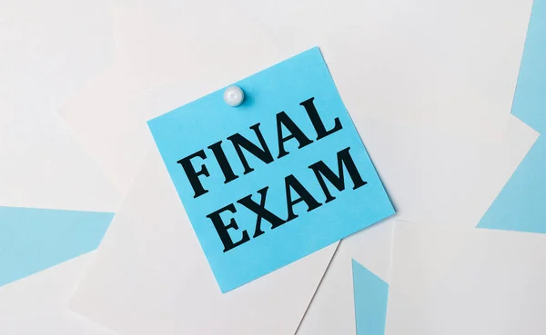 On a light blue background, white square sheets of paper. A light blue square sticker with the text FINAL EXAM is attached to them using a white paper clip.