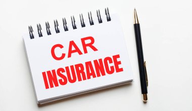 Hafif bir arka planda, beyaz bir defter içinde kelimeler olan CAR INSURANCE ve bir kalem.
