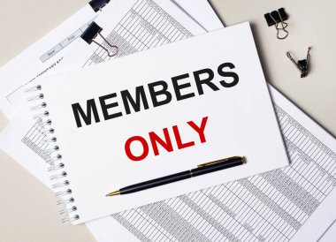 Masaüstünde dokümanlar, kalem, siyah ataçlar ve sadece metin üyeleri olan bir defter var. İş konsepti