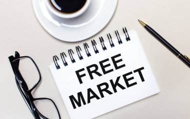 Bardaklar, beyaz bir fincan kahve, beyaz bir defter, üzerinde 